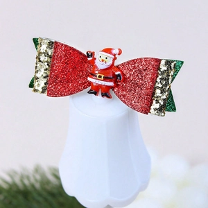 Détail d'un nœud papillon de Noël rouge scintillant avec une figurine de Père Noël