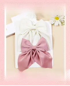 Détails de grands nœuds à cheveux en satin blanc et rose avec de longs rubans élégants