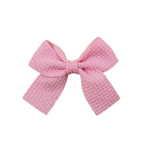 Pink waffle knit bow hair clip for children with textured fabric and ribbon center