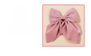 Détail d'une pince à cheveux à nœud en satin rose doux pour filles et enfants