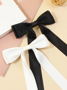 Detail of long satin ribbon hair bows in black and white with soft woven texture