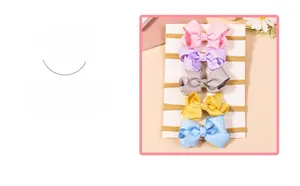 Detailed close-up of a five-piece set of colorful grosgrain bow headbands for babies