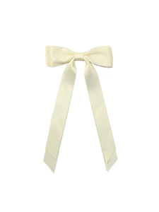 Detail of elegant cream satin hair clip with long ribbons and classic double bow design