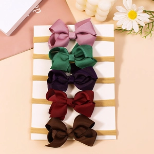 Set of 5 colorful grosgrain bow headbands for girls on white card with floral props
