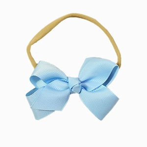 Elastic baby headband with a light blue ribbed bow on a soft nude nylon band