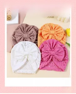 Macro detail of baby turban hats featuring hollow breathable fabric and large bows