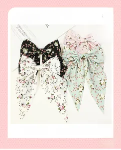 Detailed view of floral bow hair clips with long ribbons in four various colors