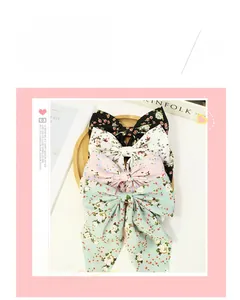 Close-up of floral ribbon bow hair clips in black, cream, pink, and mint green