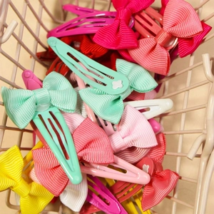 Set of 24 colorful grosgrain ribbon bow hair clips in a wire basket for girls
