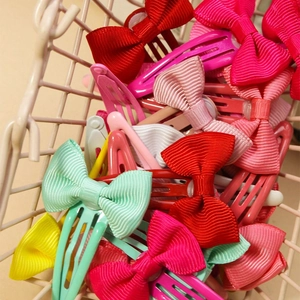 24-piece set of colorful grosgrain ribbon bow hair clips in a metal basket