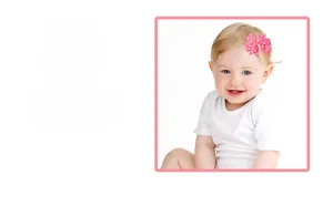 Detailed view of pink polka dot grosgrain ribbon hair clip worn by a baby model