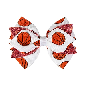 Detail of white grosgrain ribbon hair bow with basketball prints and red glitter layer