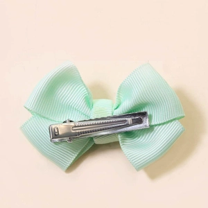 Mint green bow hair clip with ribbed ribbon texture and silver metal duckbill base