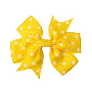 Handmade yellow grosgrain ribbon hair clip with white polka dots and hexagonal knot design