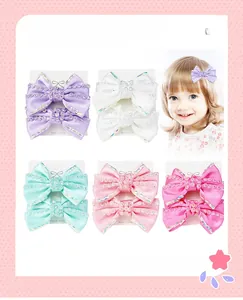 Détail de cinq barrettes à nœuds scintillants pour enfants avec strass de diverses couleurs