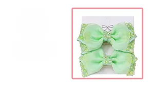Detail of light green mesh bow hair clips with sparkling rhinestones on display card
