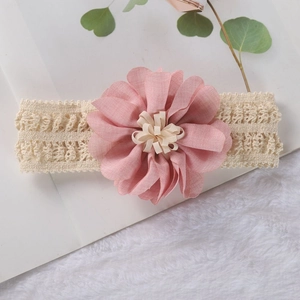 Detailed close-up of a pink chiffon flower and soft white lace headband for babies