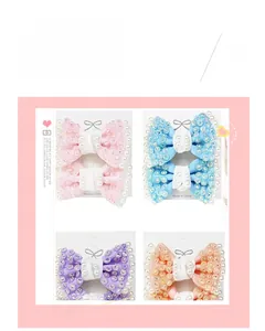 Detail of glitter hair bows with pearls in pink blue purple and orange colors