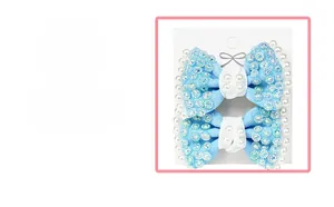 Detailed view of light blue ribbon bows with sparkling rhinestones and white pearls