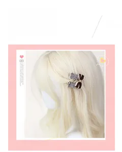 Detail of fabric bow hair clip with black-white plaid pattern on blonde hair