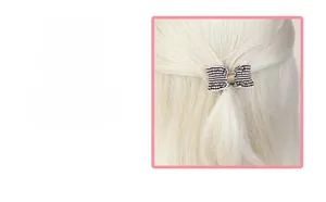 Detail showing the exquisite texture of a handmade fabric bow hair clip on blonde hair