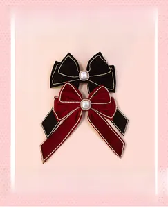 Detail of velvet bow hair clips with gold bead edges and center pearl accent