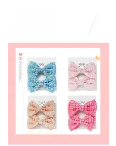 Detail view of handmade bow hair clips with rhinestones in four soft pastel colors