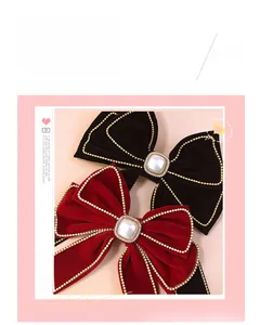 Detail of red and black velvet bow hair clips with gold bead trim and square pearl