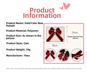 Detail view of large red velvet bow hair clip with pearl center and polyester ribbons