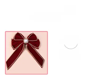Close-up of dark red velvet bow hair clip with white pearl bead edges and center stone