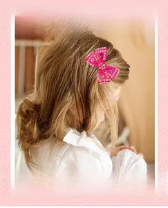 Détail d'un nœud papillon en satin rose avec strass brillants et pierres précieuses en cœur