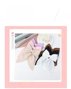Flat lay of large handmade rhinestone bow hair clips in six assorted pastel colors