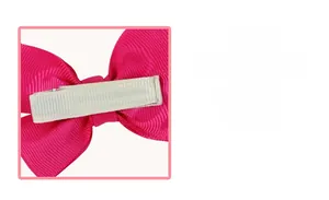 Détail de la barrette à nœud en gros-grain rose avec pince crocodile recouverte de tissu