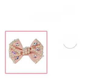 Close-up of pink ribbon hair bow with star sequins and colorful rhinestones detail