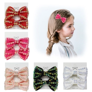 Handmade rhinestone bow hair clips for girls set in five vibrant colors with model view
