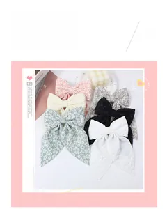Detail view of double-layered fabric bow hair clips in six assorted pastel colors
