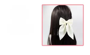 Close-up of white lace bow hair clip with elegant long ribbons on model's hair