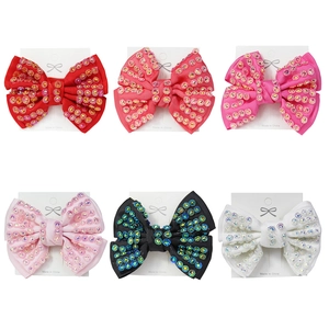 Set of six handmade rhinestone bow hair clips in various colors on display cards