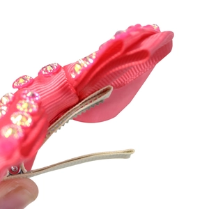 Pink handmade ribbon bow hair clip with yellow crystal rhinestones on a metal duckbill clip