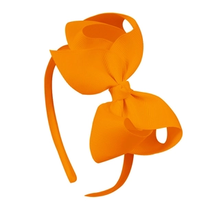 Détail du nœud papillon en ruban gros-grain orange vif sur un serre-tête pour fille