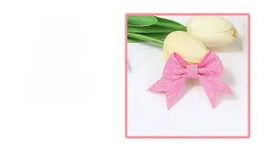 Close-up of pink glitter sequins bow hair clip showing textured fabric material and detail