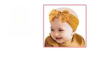 Detail showing the large handmade yellow bow headband for babies made of soft nylon fabric