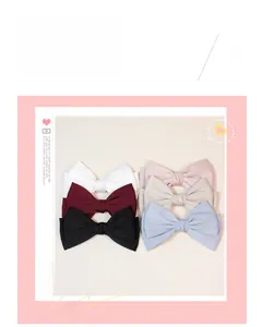 Detailed macro view of six multi-colored satin bow hair clips in various elegant shades