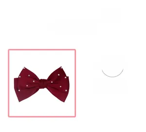 Gros plan sur une barrette à nœud en satin rouge foncé ornée de perles blanches