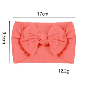 Detailed view of coral pink nylon baby headband with dimensions 17x9.5cm and bow knot