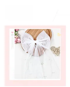 Détail d'un nœud de mariée en tulle blanc avec perles élégantes et long voile fluide