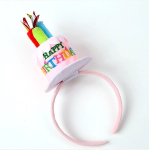 Close-up of pink plush birthday headband with Happy Birthday embroidery and candles
