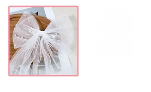 Vue détaillée du nœud de mariée en tulle blanc avec perles élégantes sur maille douce