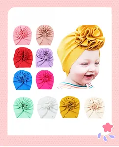 Macro detail of infant turban hats with soft waffle knit texture and large floral accents