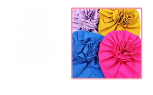 Detailed close-up of textured knit baby turbans with decorative floral petal pleats